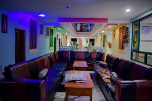 a restaurant with couches and tables in a room at The Joy Hotel in Voi