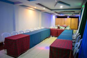 a conference room with red and blue tables and chairs at The Joy Hotel in Voi