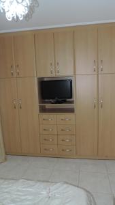 a room with wooden cabinets with a tv and a tvictericter at Penthouse Deluxe apartment at piraeus in Piraeus