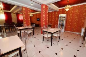 a restaurant with tables and chairs and a refrigerator at Hotel Acropolis Palace in Kabardinka