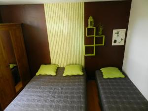 een kleine slaapkamer met twee bedden en gele kussens bij Mas denis in Arles