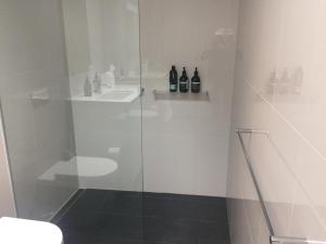 a bathroom with a glass shower with a sink at Quarry House Luxury Retreat in Hobart