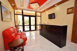 a living room with a red leather couch and a counter at Hotel Acropolis Palace in Kabardinka