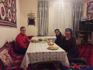 a group of people sitting around a table at Guest House Guljan in Bokonbayevo