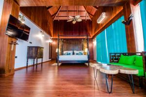 a bedroom with a bed and a green couch at Symphony Summer Sands Beach Resort And Spa in Neil Island