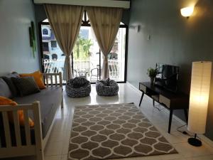 a living room with a couch and a tv and a room with a table at Pino's Place in Kuah
