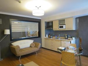 a kitchen and living room with a couch and a table at Tempo Residence Comfort Izmir in Izmir