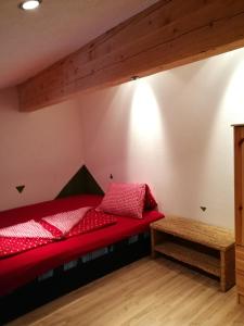 ミッタージルにあるMosenbauer Ferienwohnung Salzburgの屋根裏部屋 赤いベッド付