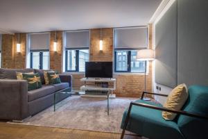 a living room with a couch and a tv at Soho One in London
