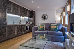 a living room with a blue couch and a glass table at Soho One in London