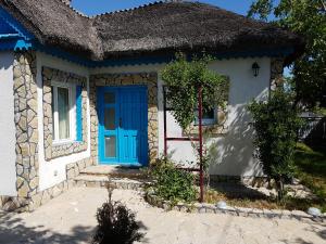 uma pequena casa branca com uma porta azul em Casa Anica em Sulina
