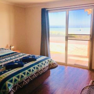 a bedroom with a bed and a view of the ocean at Bay Lodge in Denham