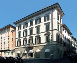 a large white building with flags in front of it at Hotel Arizona in Florence