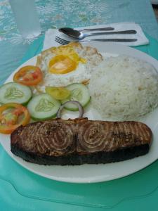 un plato de comida con carne y arroz en una mesa en Villa Feliza, en Loboc