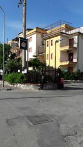 an empty street with a fence and a building at village du soleil in Giardini Naxos