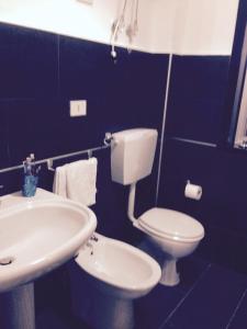 a bathroom with a white toilet and a sink at village du soleil in Giardini Naxos