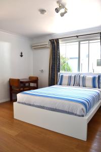 a bedroom with a large bed with a window at Busselton Ithaca Motel in Busselton