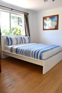 two beds in a bedroom with a window at Busselton Ithaca Motel in Busselton
