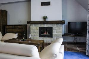 a living room with a fireplace and a tv at Penzión SIMI in Tatranská Lomnica +110 photos