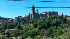 une ville au sommet d'une colline avec des bâtiments dans l'établissement Il Pozzo Della Citerna, à Castelnuovo Berardenga