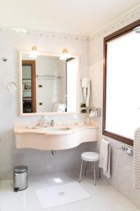 a bathroom with a sink and a mirror at Phi Hotel Dei Medaglioni in Correggio