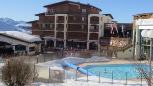 a swimming pool with a slide in front of a building at Les deux Alpes studio in Les Deux Alpes