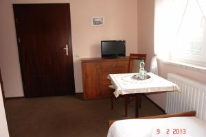 a room with a table and a television and a door at Pokoje Hotelowe Wiktoria in Goczałkowice Dolne