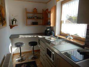 a kitchen with a sink and a counter with stools at Zum Stadtwald in Spremberg