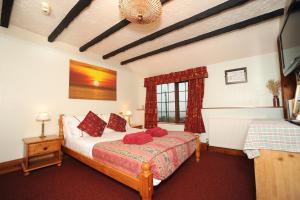 a bedroom with a bed with red pillows at The West Country Inn in Clovelly