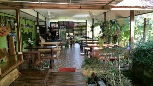 a restaurant with wooden tables and benches and tables at Khao Sok Blue Mountain in Khao Sok National Park