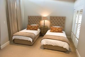 a bedroom with two beds with pillows and a lamp at 14 On Louw in Stellenbosch