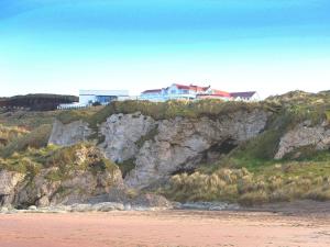 a house on top of a cliff next to a beach at Royal Court Hotel in Portrush