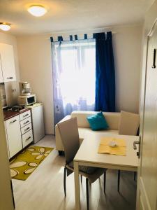 a small living room with a table and a kitchen at Guest House Jadro in Rovinj