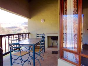 a dining room with a table and chairs on a balcony at 124 Fairways Drakensberg Gardens in Underberg