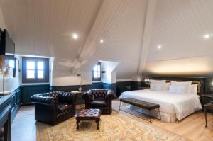 a bedroom with a bed and two chairs and a table at La Casa del Presidente Small Luxury Hotels in Ávila +46 photos