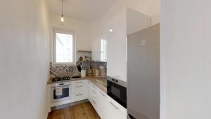 a kitchen with white cabinets and a window at Old Town Loft in Žilina