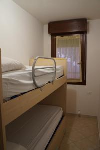 sypialnia z dwoma łóżkami piętrowymi i oknem w obiekcie Residence Corallo w mieście Rosolina Mare +19 zdjęć