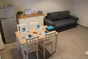 - un salon avec une table, des chaises et un canapé dans l'établissement Casa Mirò, à Polignano a Mare