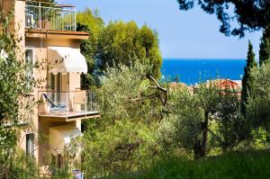 a building with a balcony and the ocean in the background at Hotel Mediterraneo in Laigueglia