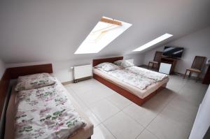 a attic bedroom with two beds and a skylight at Willa Marteczka in Rowy