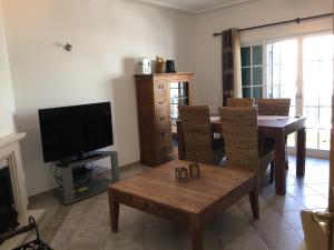 a living room with a table and a television at SS Tavira in Cabanas de Tavira