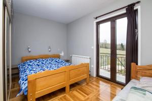 a bedroom with a bed and a large window at Apartmani Tarsko Sunce in Kaludjerske Bare