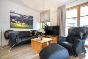 a living room with a couch and a tv at Alpin Lodge in Oberstdorf