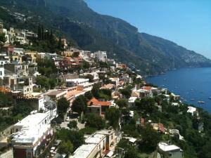 a town on a hill next to a body of water at Hotel Posa Posa in Positano