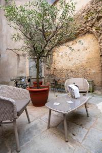 ein Tisch und zwei Stühle mit Weingläsern drauf in der Unterkunft Abbaye de Maizières in Beaune