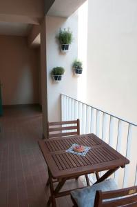 a wooden table and chairs on a balcony with potted plants at Spacious balcony apartment Piran in Piran
