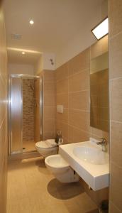 bagno con 2 servizi igienici, lavandino e doccia di Hotel Belvedere Spiaggia a Rimini