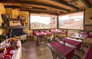 un restaurante con mesas y sillas y una chimenea en Archontiko, en Mystras