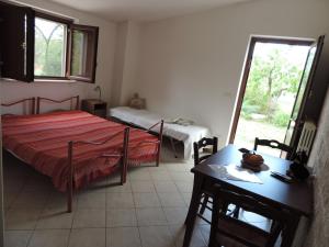1 dormitorio con 2 camas, mesa y ventana en Masseria dei Monelli, en Conversano