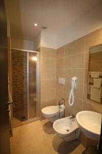Hotel Belvedere Spiaggia في ريميني: حمام مع مغسلتين ودش ومرحاض